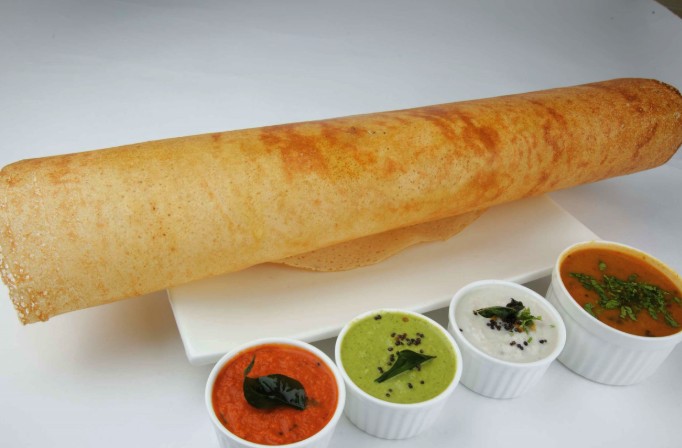 Crispy golden South Indian Dosa served on a traditional banana leaf at Godavarii