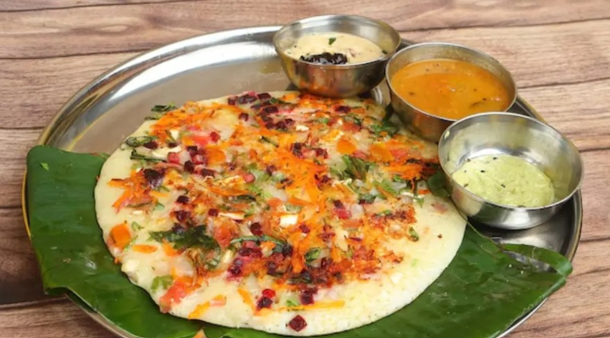 Thick classic South Indian Uttapam pancake topped with fresh onions and green chillies